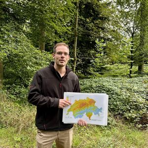 Philipp Egloff hält eine Klimakarte der Schweiz