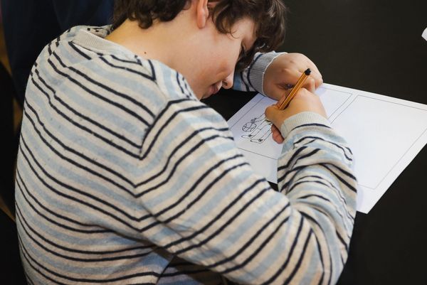 Kind zeichnet einen Comic im Workshop